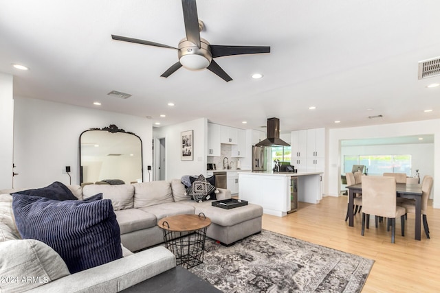 living room with light hardwood / wood-style flooring and ceiling fan