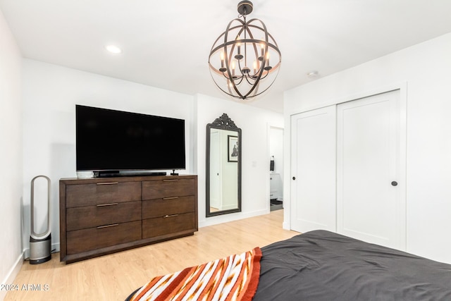 bedroom with light wood-type flooring, a closet, and a notable chandelier