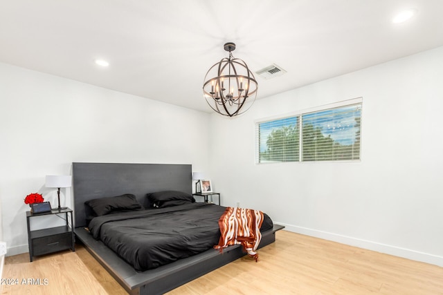 bedroom featuring a notable chandelier and light hardwood / wood-style flooring