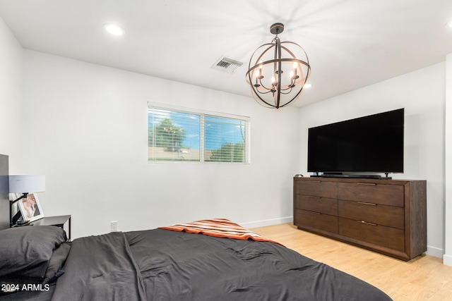 bedroom featuring light hardwood / wood-style floors and a notable chandelier