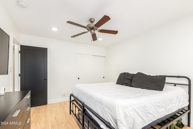 bedroom featuring ceiling fan, light hardwood / wood-style floors, and a closet