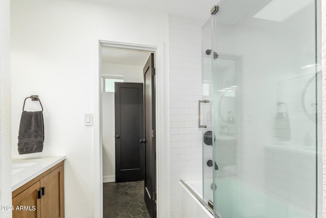 bathroom with tile patterned flooring, vanity, and enclosed tub / shower combo