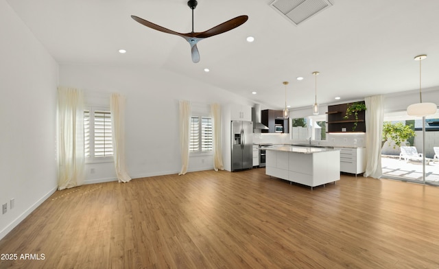 6833 E Grandview Dr, Scottsdale, AZ 85254 - interior space with visible vents, open shelves, wall chimney range hood, appliances with stainless steel finishes, and a kitchen island