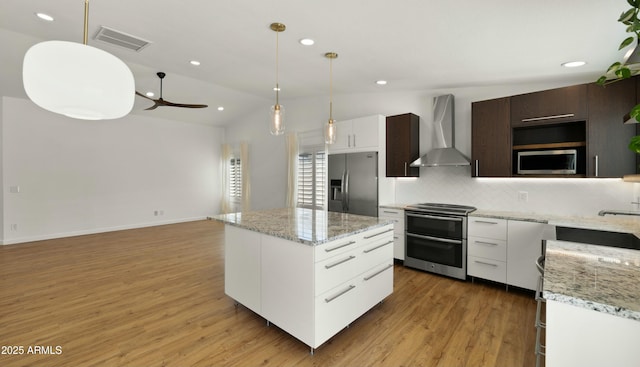 6833 E Grandview Dr, Scottsdale, AZ 85254 - kitchen with visible vents, wall chimney exhaust hood, a ceiling fan, stainless steel appliances, and decorative backsplash