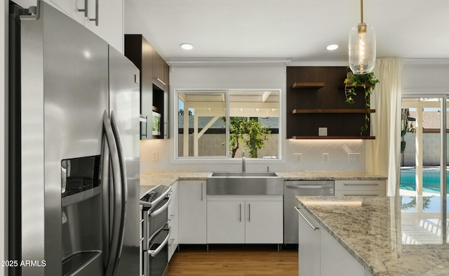 6833 E Grandview Dr, Scottsdale, AZ 85254 - kitchen with white cabinets, appliances with stainless steel finishes, a sink, decorative light fixtures, and decorative backsplash