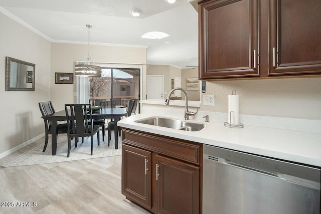 kitchen with sink, crown molding, light hardwood / wood-style flooring, stainless steel dishwasher, and pendant lighting