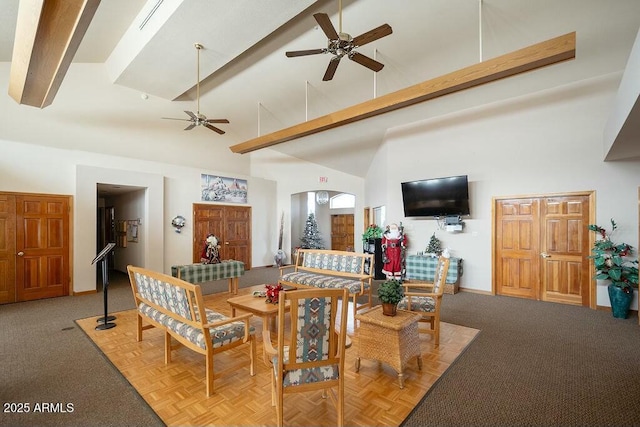 living room featuring ceiling fan, high vaulted ceiling, and beamed ceiling