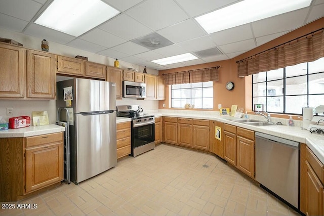 kitchen featuring a drop ceiling, sink, and appliances with stainless steel finishes