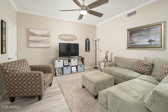 living room featuring ceiling fan, ornamental molding, and light wood-type flooring