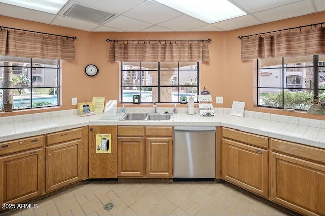 kitchen featuring stainless steel dishwasher, a paneled ceiling, and sink