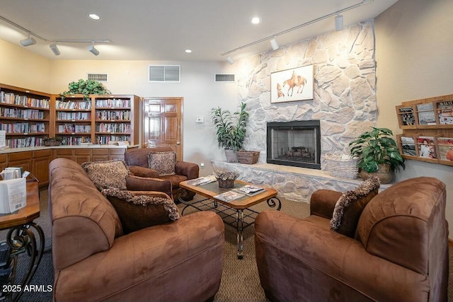 living room with track lighting and a fireplace