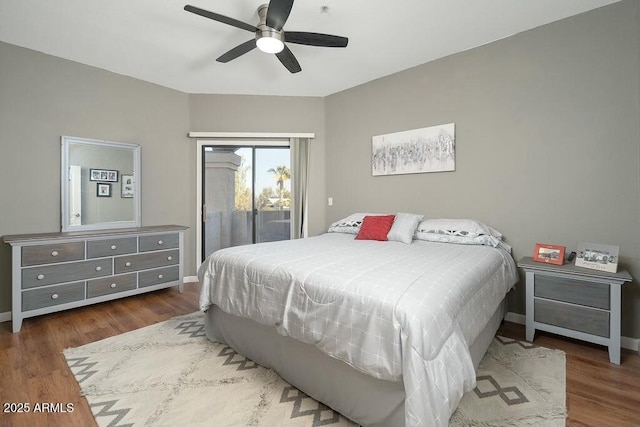 bedroom with dark wood-type flooring, ceiling fan, and access to outside