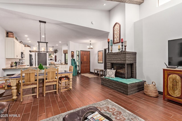 1235 N Sunnyvale Unit 113, Mesa, AZ 85205 - living room featuring dark wood finished floors, high vaulted ceiling, and a brick fireplace