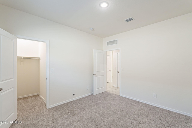 19354 W Coolidge St, Litchfield Park, AZ 85340 - unfurnished bedroom featuring light carpet, baseboards, visible vents, and a walk in closet