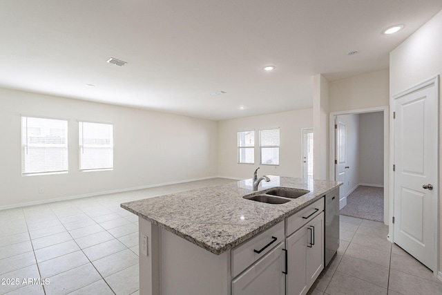 19354 W Coolidge St, Litchfield Park, AZ 85340 - kitchen featuring light tile patterned flooring, a sink, stainless steel dishwasher, light stone countertops, and a center island with sink