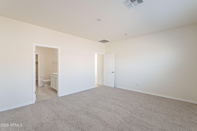 19354 W Coolidge St, Litchfield Park, AZ 85340 - unfurnished bedroom with light colored carpet, visible vents, baseboards, and ensuite bathroom