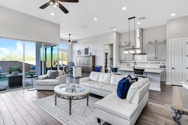 living room with ceiling fan, sink, and a high ceiling