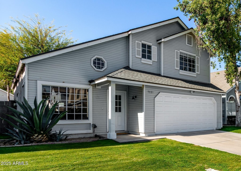 view of front of house featuring a garage and a front lawn