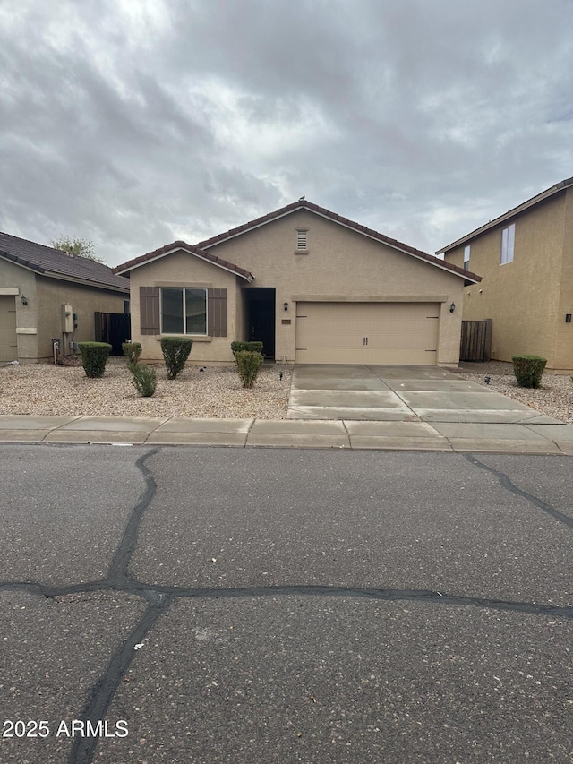 single story home with stucco siding, a garage, central AC, and driveway