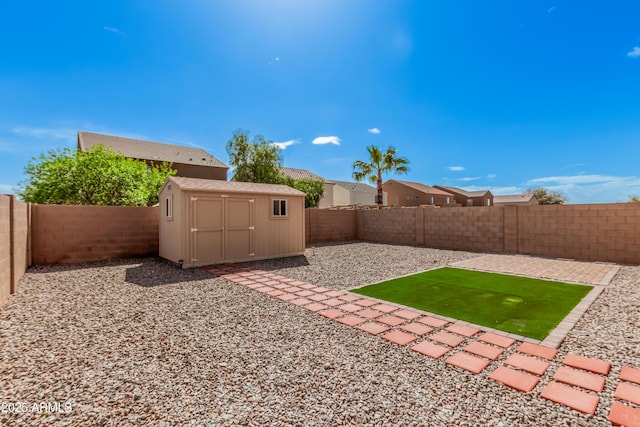 view of yard with a storage shed, an outbuilding, a fenced backyard, and a patio area