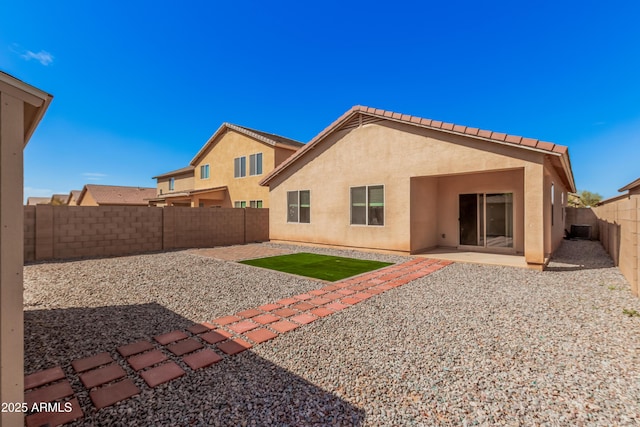 back of property with stucco siding, cooling unit, a fenced backyard, and a patio area