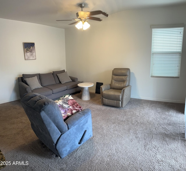 carpeted living area with ceiling fan and baseboards