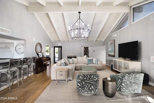 living room featuring high vaulted ceiling, hardwood / wood-style floors, beamed ceiling, and a notable chandelier