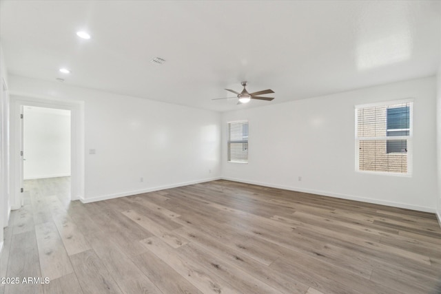 empty room with ceiling fan and light hardwood / wood-style flooring