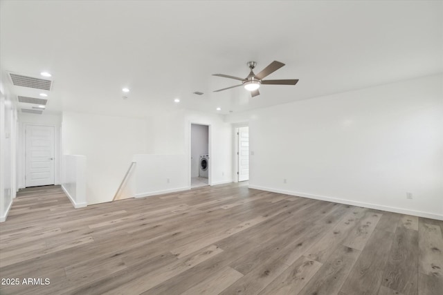 empty room featuring washer / clothes dryer, ceiling fan, and light hardwood / wood-style flooring