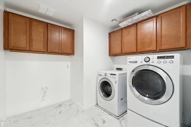 washroom featuring washing machine and dryer and cabinets