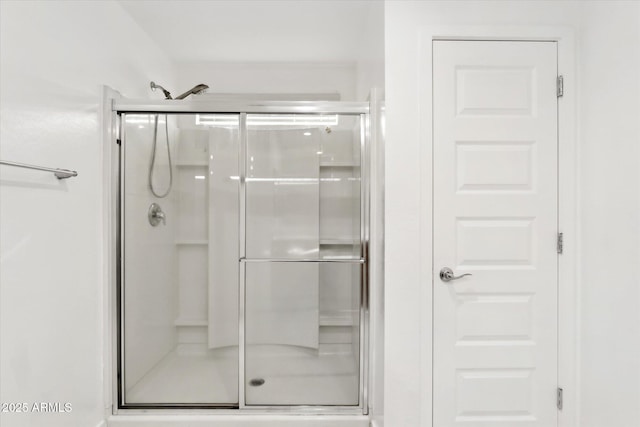 bathroom with a shower with door