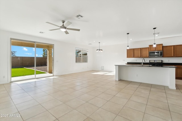 kitchen featuring stainless steel appliances, a wealth of natural light, and decorative light fixtures