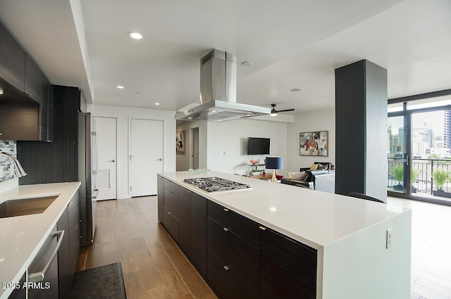 kitchen with a sink, a ceiling fan, modern cabinets, stainless steel appliances, and island exhaust hood