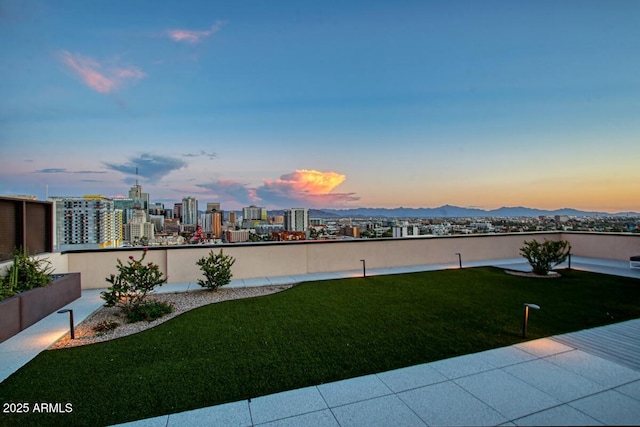 yard at dusk featuring a city view