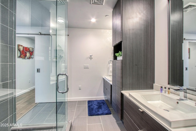 full bath with vanity, a shower stall, tile patterned flooring, baseboards, and visible vents