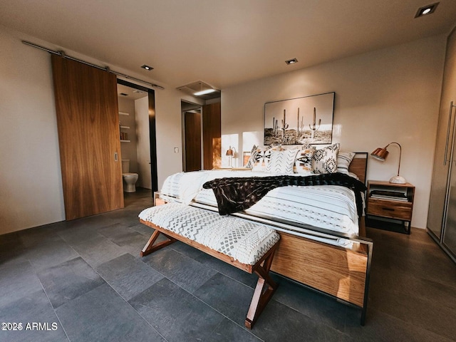 bedroom with connected bathroom and a barn door