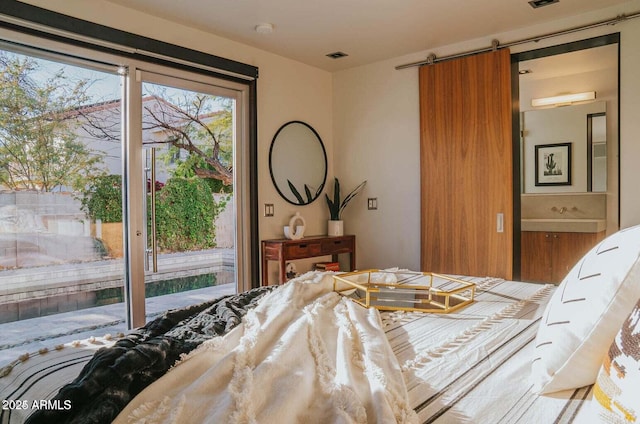 bedroom with access to outside and a barn door