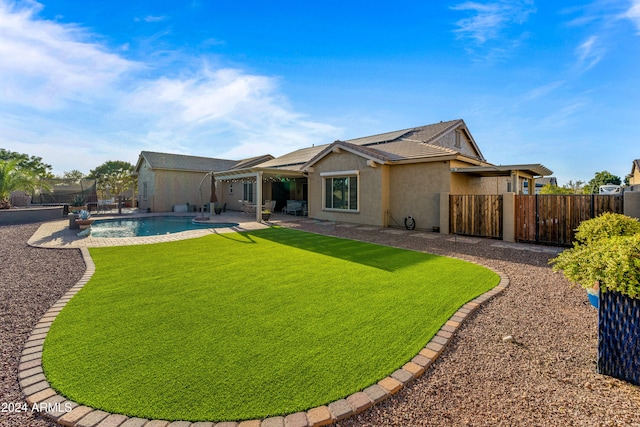 back of house featuring a patio area, a fenced in pool, and a yard