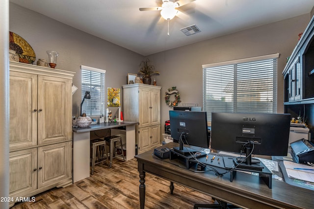 office space with built in desk, light hardwood / wood-style flooring, and ceiling fan