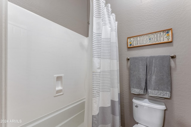 bathroom with curtained shower and toilet