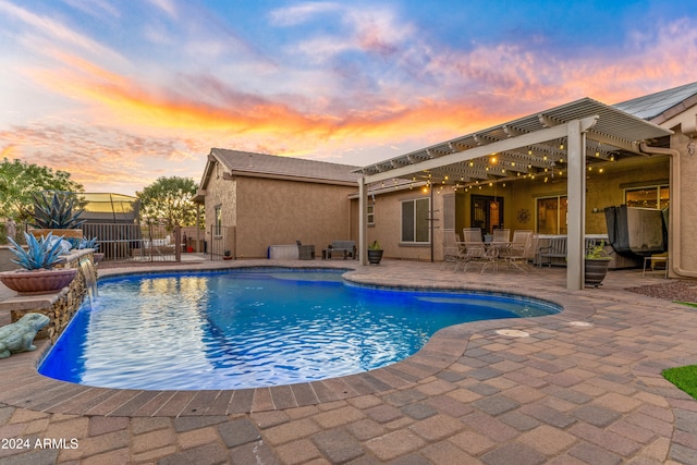 pool at dusk featuring a pergola and a patio