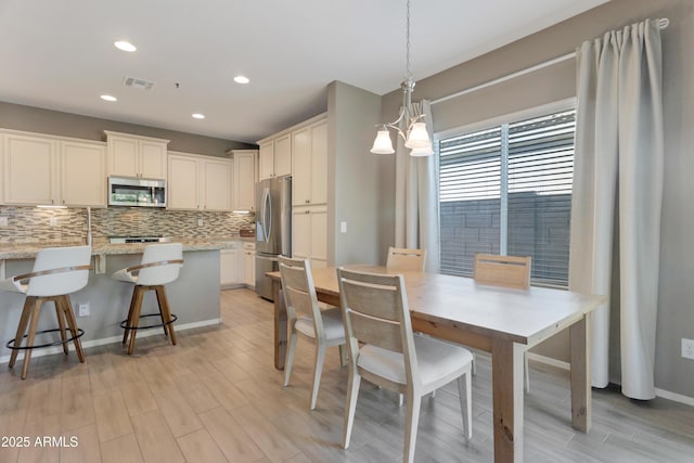 dining room featuring recessed lighting, baseboards, light wood finished floors, and visible vents