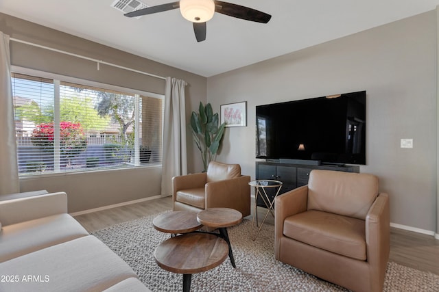 living room featuring baseboards, ceiling fan, wood finished floors, and visible vents