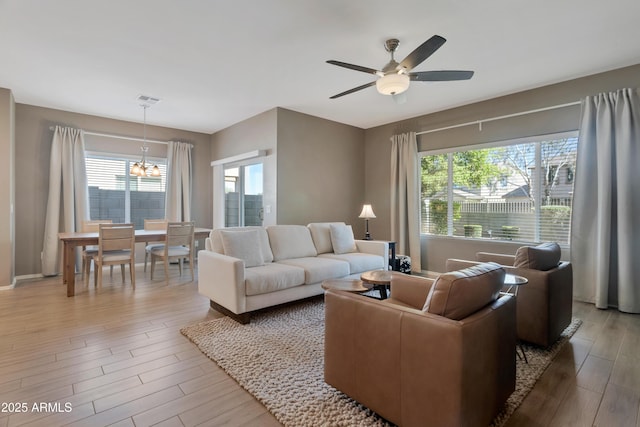 living room with visible vents, a ceiling fan, baseboards, and wood finished floors