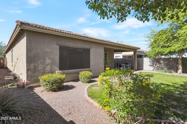 back of house with fence and stucco siding