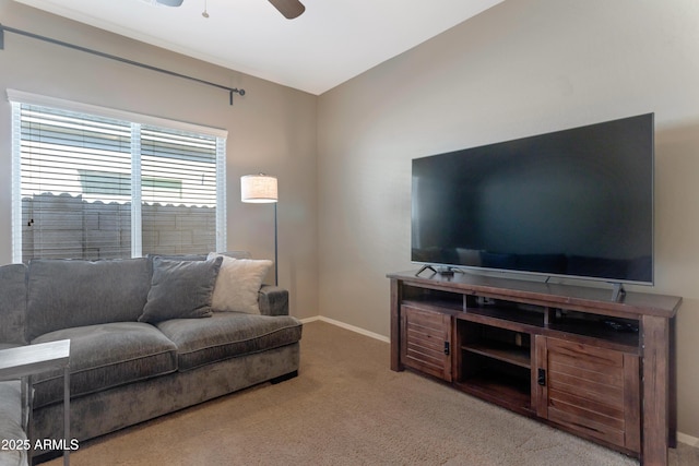living area with baseboards, ceiling fan, and carpet