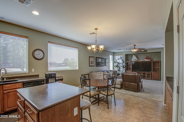 kitchen with a sink, visible vents, a wealth of natural light, brown cabinets, and dark countertops