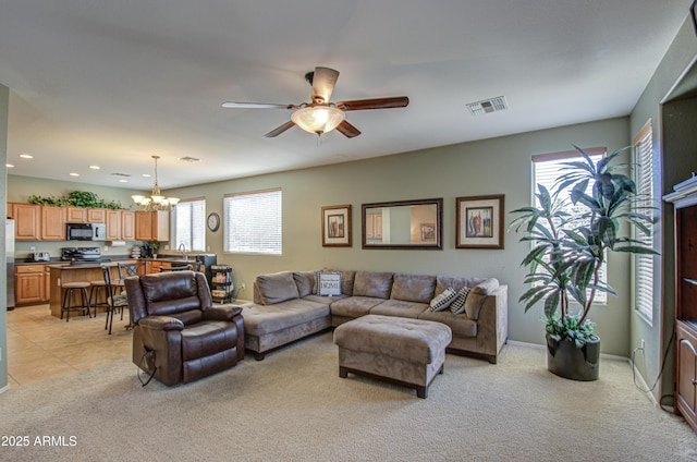 living area featuring light colored carpet, visible vents, recessed lighting, and ceiling fan with notable chandelier