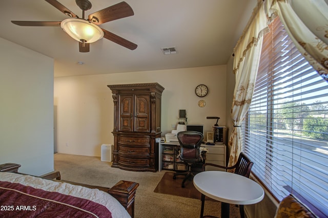 carpeted bedroom featuring ceiling fan and visible vents