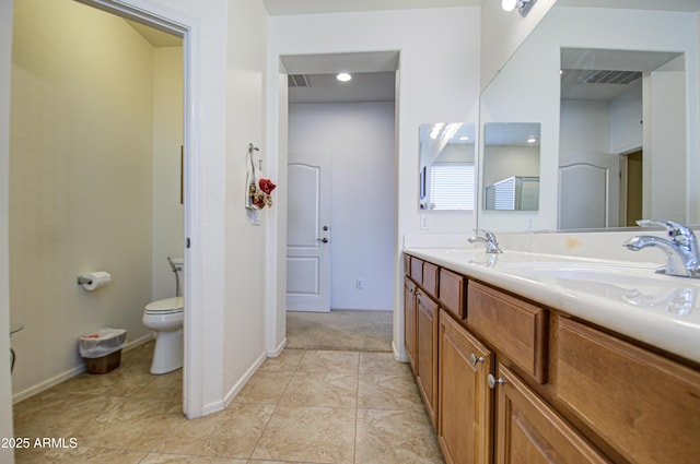 full bathroom featuring toilet, double vanity, visible vents, and a sink